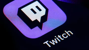 Логотип Twitch на светодиодном экране в контексте коллективного иска стримеров против Amazon из-за обучения ИИ-моделей