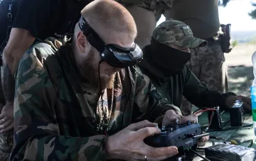 Оператор БПЛА в камуфляже управляет FPV-дроном с помощью VR-очков и пульта — техника, применяемая ВСУ для ударов по объектам в Крыму