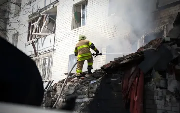 Feuerwehrmann löscht Feuer auf Trümmern eines zerstörten Wohngebäudes in Tschernihiw nach einem Drohnenangriff