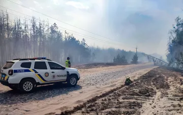 Полицейский автомобиль на месте лесного пожара в Украине во время чрезвычайной пожарной опасности