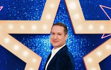 Піаніст MAESTROPIANO, 41-річний киянин, на сцені шоу «Україна має талант» на тлі великої світлодіодної зірки логотипу після виграшу першої «Золотої кнопки»