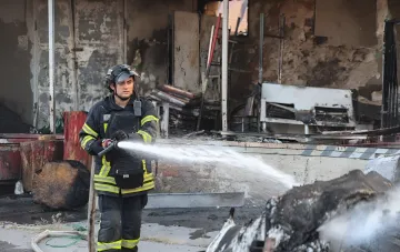 Firefighter douses the burnt interior of an EpiCentre hypermarket in Odesa after a massive attack