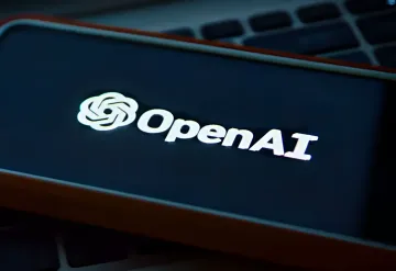 OpenAI-Logo auf dem Smartphone-Display, das auf einer Laptop-Tastatur liegt