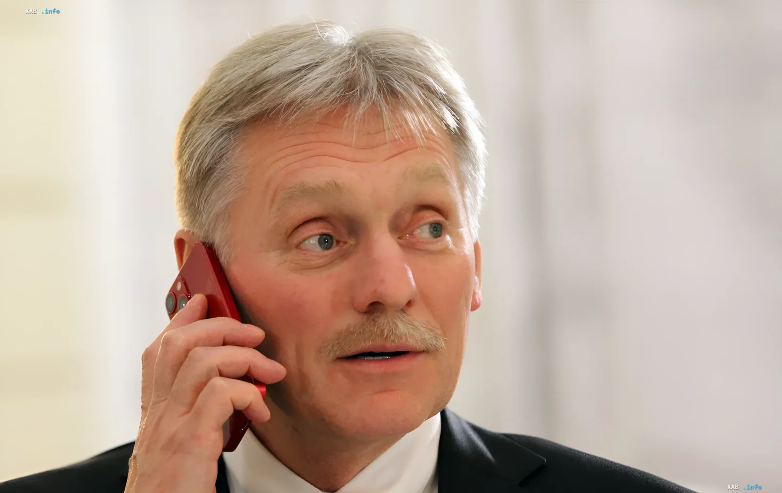 Dmitry Peskov on a phone call with a red smartphone, commenting on strikes on Ozon and warning Kyiv of daily and nightly responses