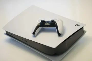 Консоль PlayStation 5 и геймпад DualSense на фоне протеста геймеров за возврат физических дисков