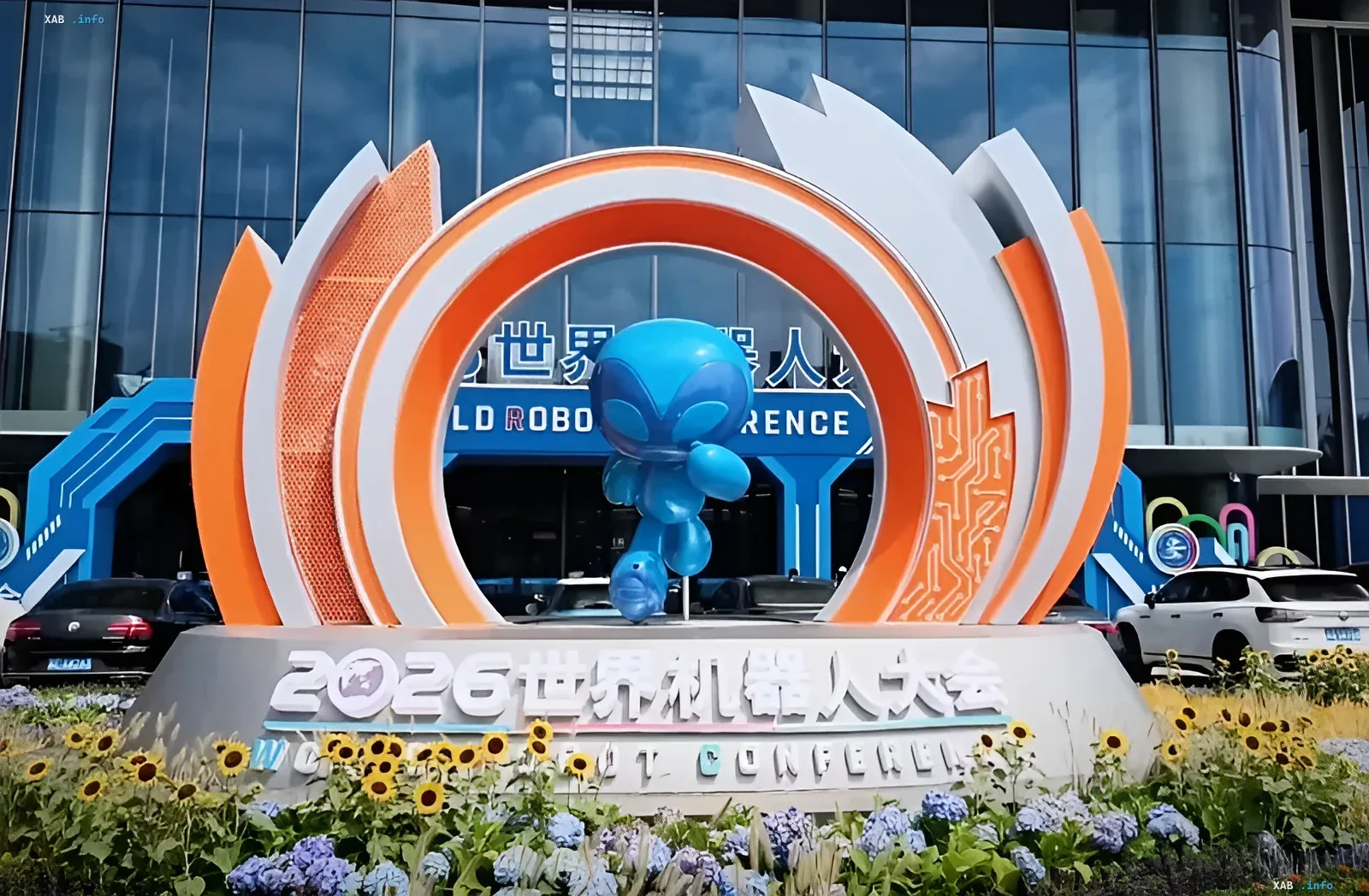 Entrance to the 2026 World Robot Conference: an orange-and-white arch with a blue robot mascot against a glass pavilion — the stage where RealMan Robotics showcases RealBOT robots for real-world workplaces