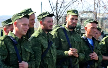 Российские военнослужащие в камуфляжной форме на фоне военной техники во время проверки готовности к мобилизации
