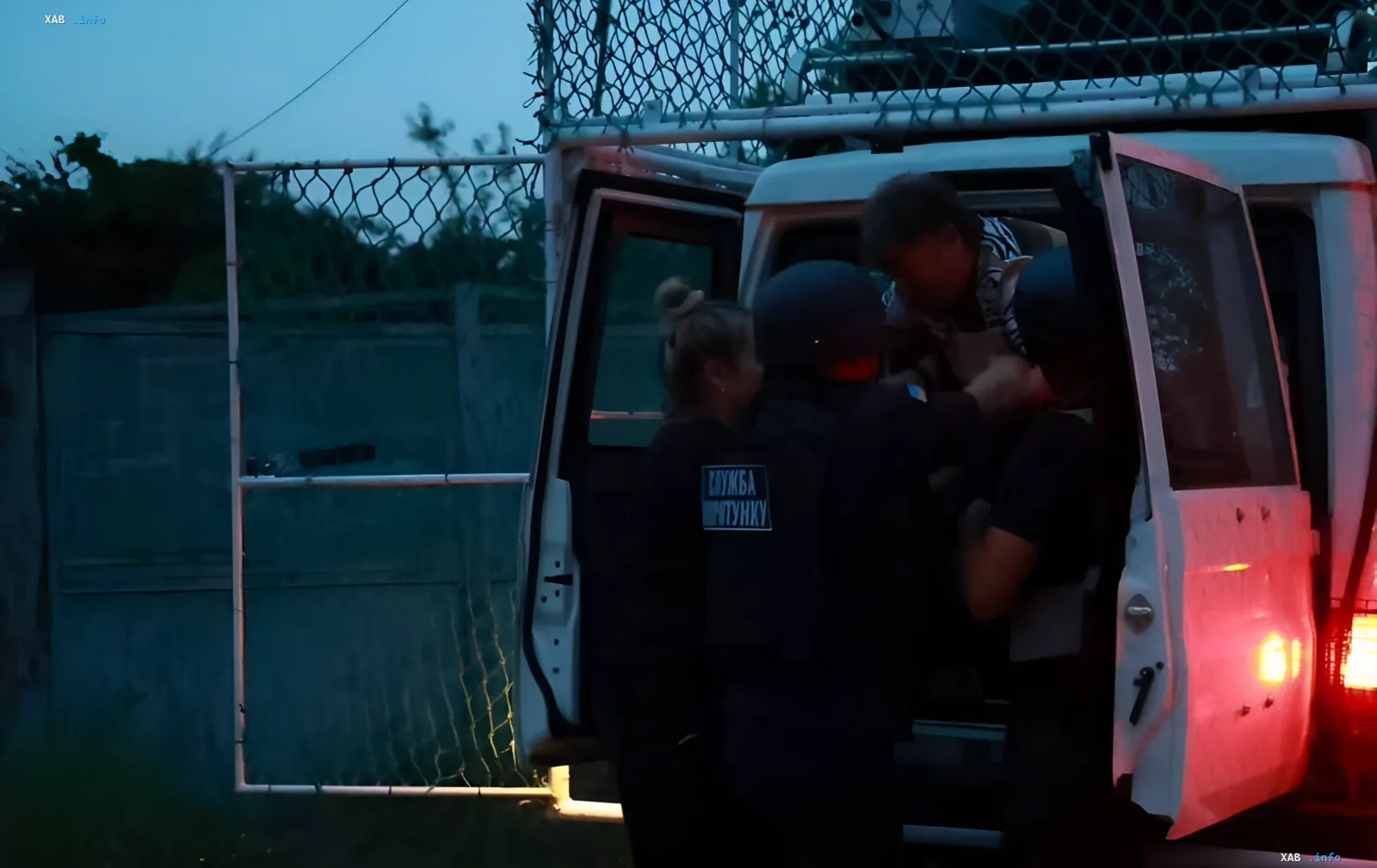 Rescue service workers help an injured person into an official vehicle after a strike on a Kharkiv suburb