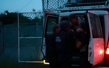Rescue service workers help an injured person into an official vehicle after a strike on a Kharkiv suburb