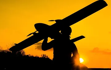 Силует бійця з тактичною ракетою на тлі заходу сонця — ракетні комплекси, для яких вироблялося паливо на ураженому заводі «Каменський»