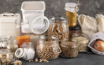 Long-term food stockpile in glass jars and cloth bags: pasta, legumes, grains and onion for a blackout ration during a power outage