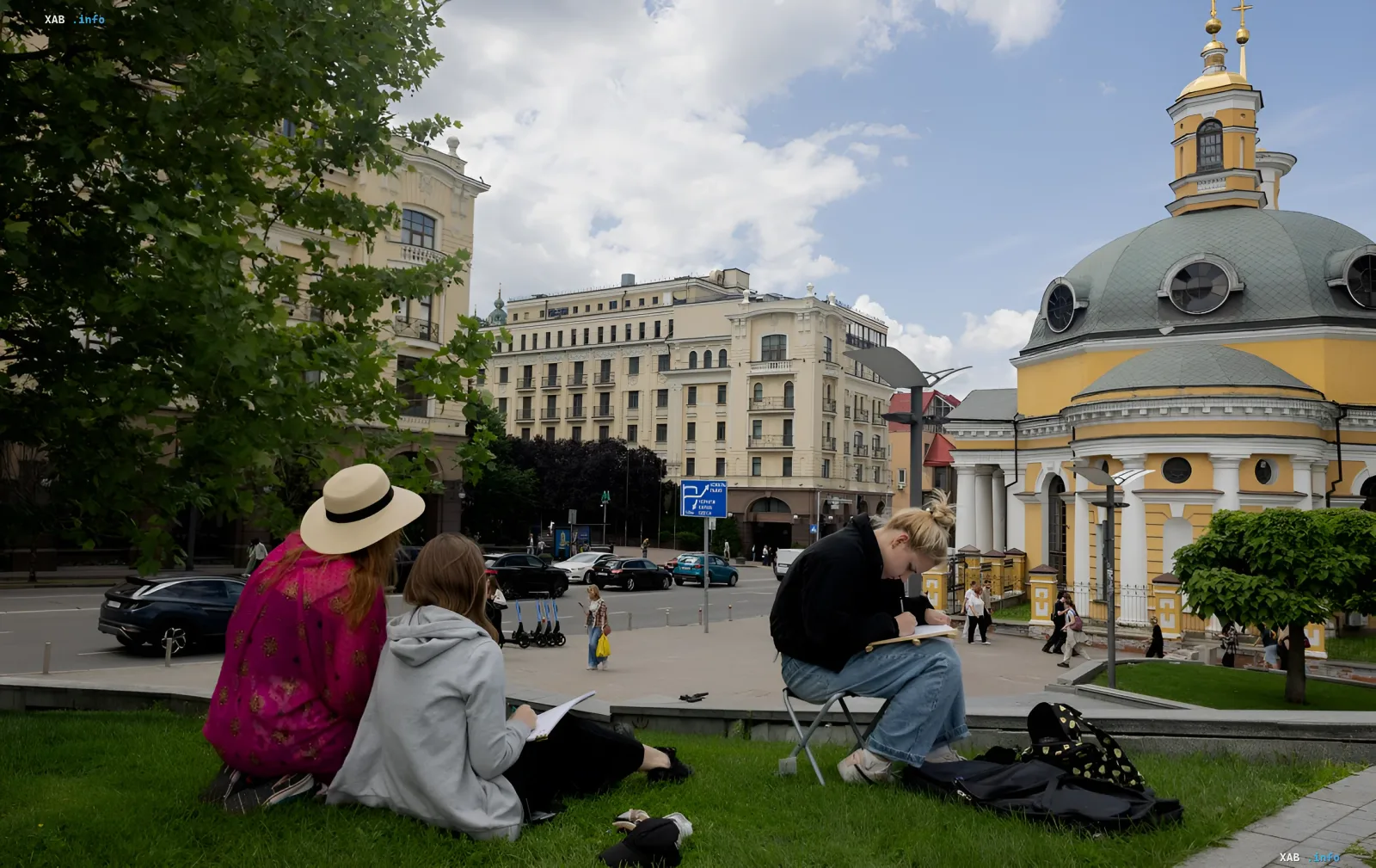 Студенты рисуют на траве в городском сквере Украины под переменчивым небом перед приходом атмосферного фронта с дождями и грозами 26–28 августа