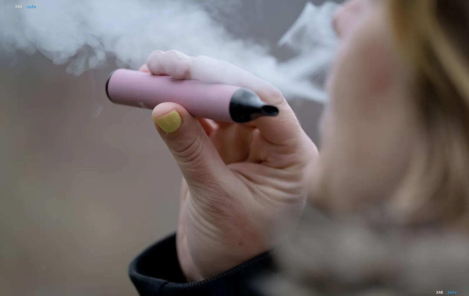Person raucht eine rosa E-Zigarette mit dichtem Dampf im Hintergrund — Illustration zum Kantar-Report, wonach 93,3 % der E-Zigaretten in der Ukraine dem Gesetz nicht entsprechen