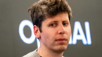 Sam Altman, Mitgründer von OpenAI, vor dem leuchtenden Firmenlogo bei einem Vortrag über die Risiken der KI-Konzentration