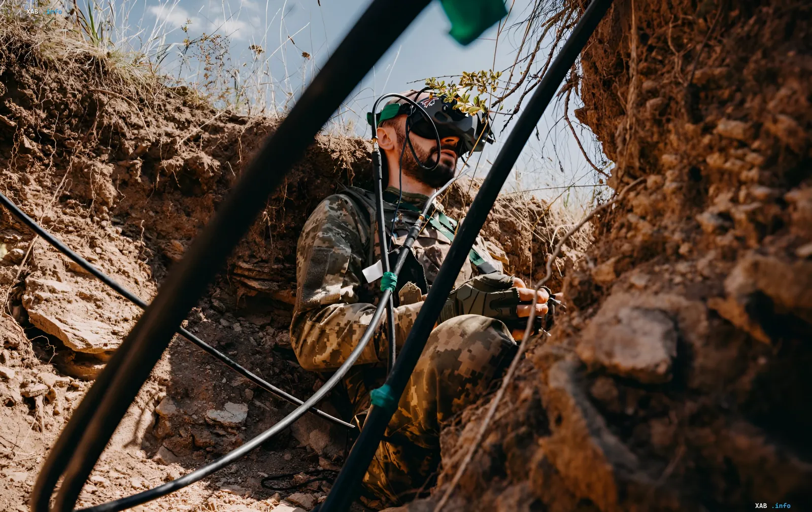 Defense Forces soldier in digital camouflage wearing a VR headset in a trench during simulation training for strikes on Russian rear targets