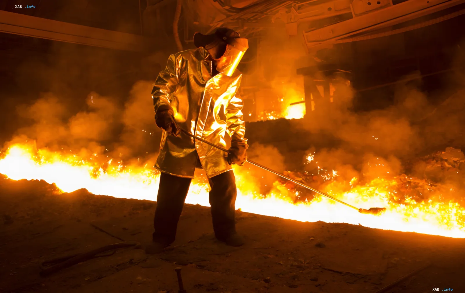 Metallurgist in a reflective protective suit working over a molten metal bath at a Ukrainian steel plant