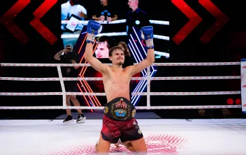 Ukrainian Muay Thai fighter with Artan Fighting Series championship belt in the ring in Vinnytsia