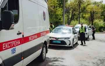 Службы экстренного реагирования на месте атаки дронов по бизнес-центру в Лозовой: машина скорой помощи и полицейский автомобиль