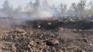 Место взрыва в селе Песчанка Днепропетровской области: воронка в земле и дым