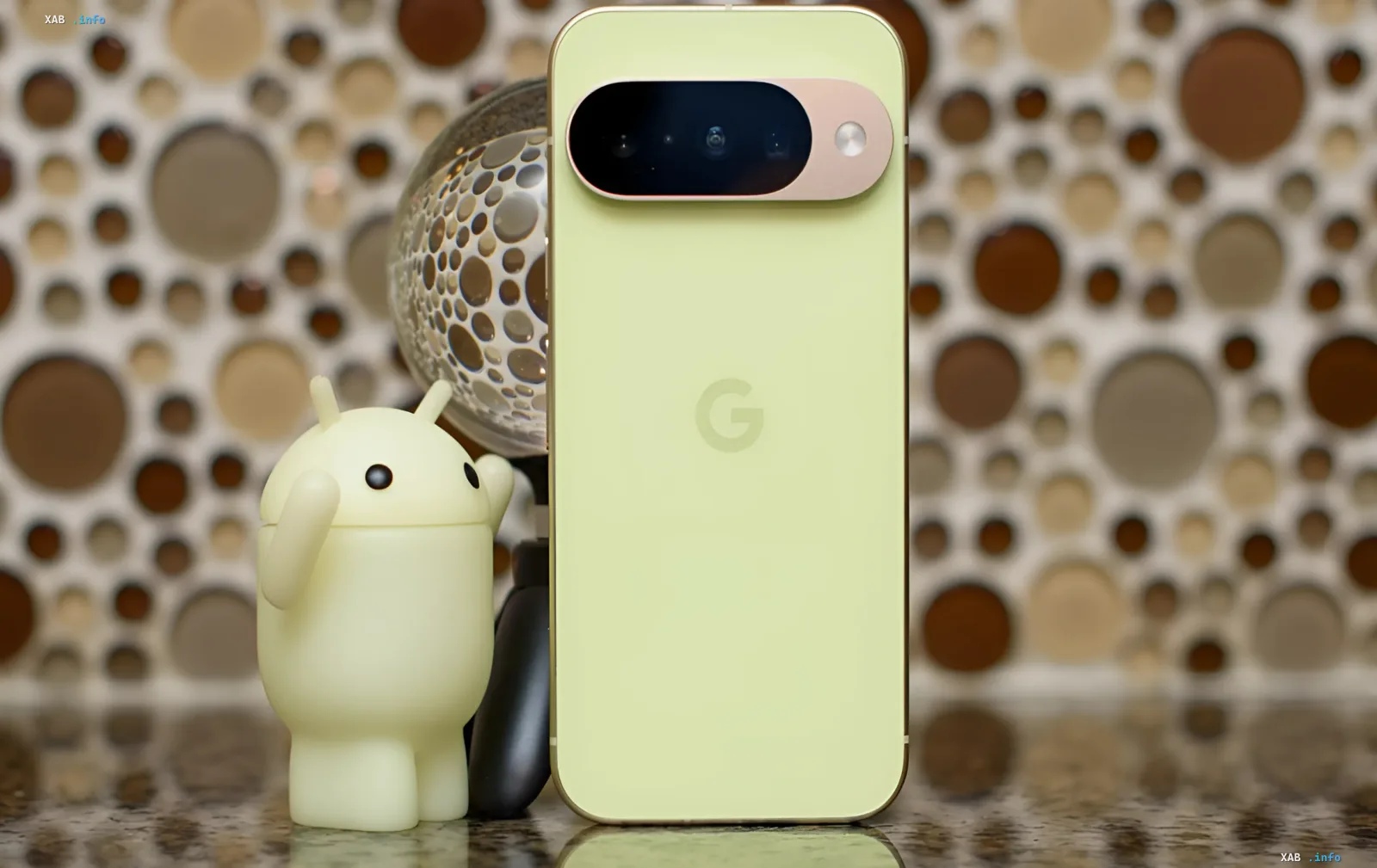 Lime-green Google Pixel 11 smartphone with camera bar and G logo next to an Android figurine — the Tensor G6 flagship chip that disappointed in performance