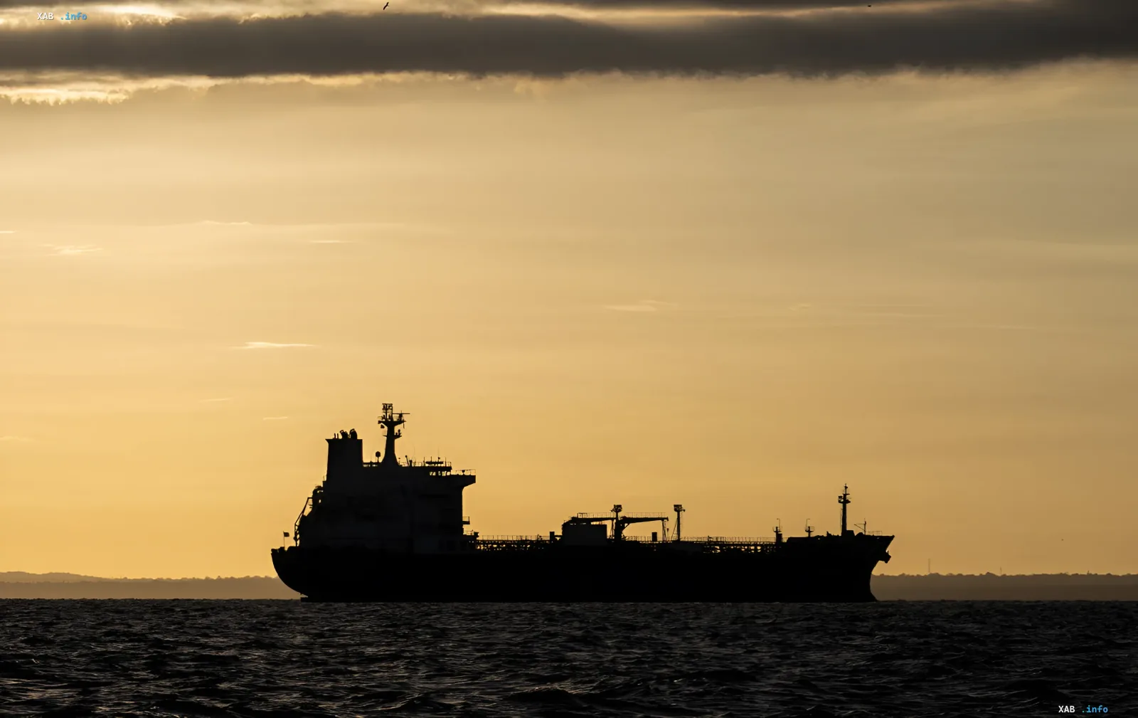 Silhouette of an oil tanker at sunset — a symbol of seaborne Russian oil shipments to India that are now declining