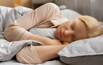 Eine schlafende Frau im Bett, die das Thema Träume von einem Ex-Partner und deren psychologische Analyse illustriert