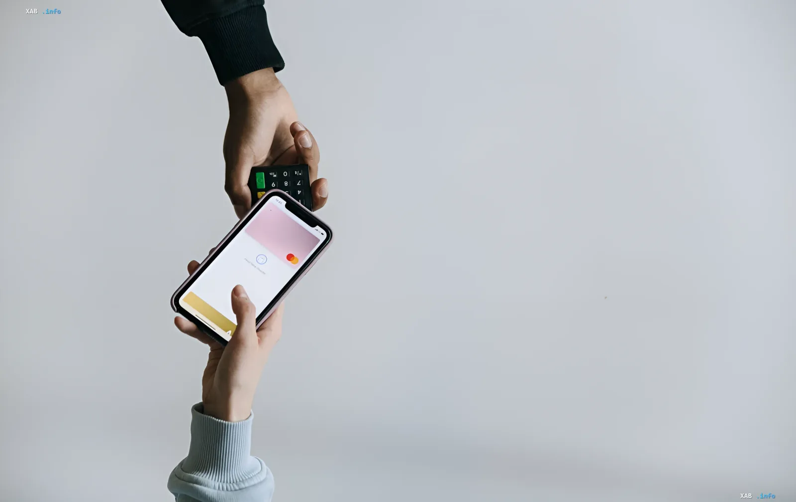 Handing over a smartphone with Apple Wallet open for contactless payment on iPhone