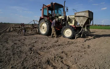 Landwirt arbeitet mit einem Belarus-Traktor auf dem Feld im Rahmen des Ernte-Speicherprogramms der Ukraine
