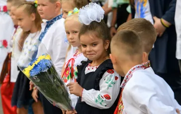 Школьники в традиционных украинских вышиванках с цветочной вышивкой перед 1 сентября