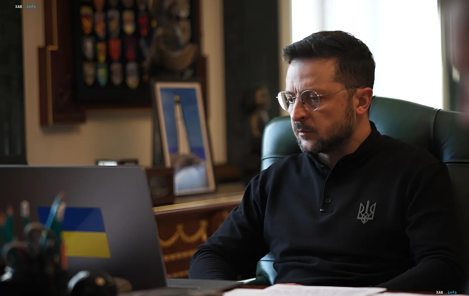Владимир Зеленский в кабинете за ноутбуком с флагом Украины перед совещанием с командованием ВСУ по обороне Запорожья и Донбасса
