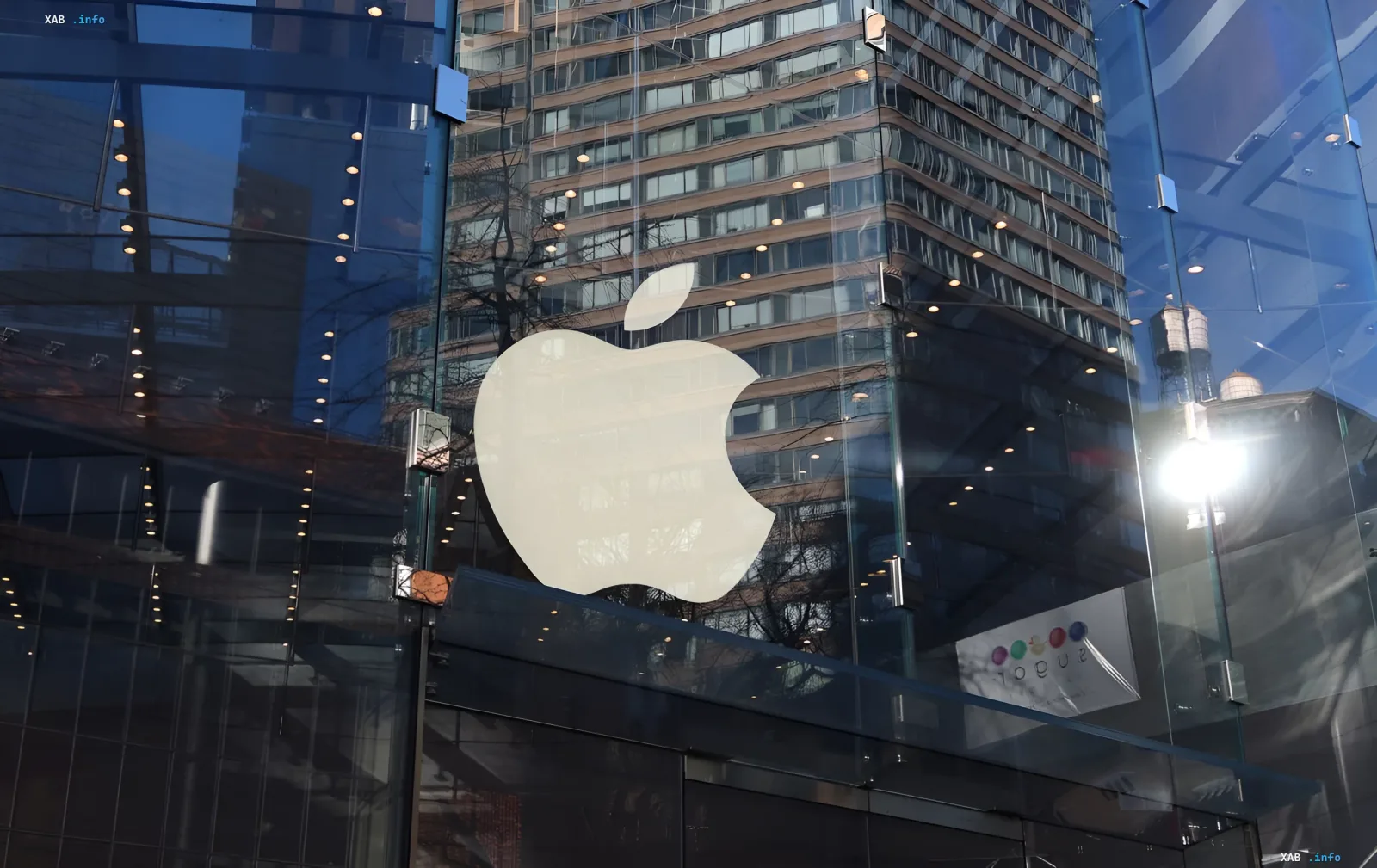 Логотип Apple на стеклянном фасаде магазина перед презентацией новых iPhone и складного смартфона 9 сентября