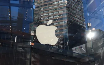 Логотип Apple на стеклянном фасаде магазина перед презентацией новых iPhone и складного смартфона 9 сентября