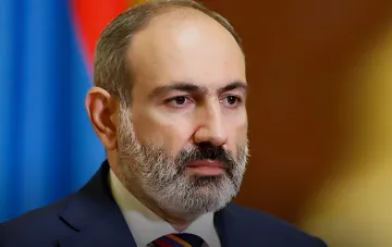 Porträt eines armenischen Politikers vor der Nationalflagge im Kontext der Streichung Russlands aus der Liste der strategischen Verbündeten in der Regierungsprogramm Armeniens für 2026–2031