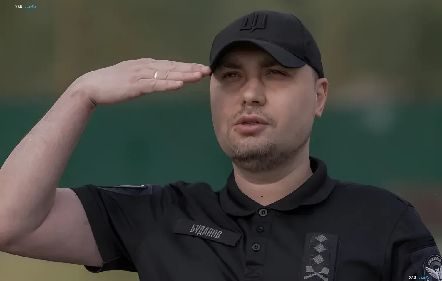 Кирило Буданов у військовій формі salutує на тлі зеленого фону