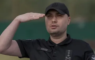 Kyrylo Budanov in military uniform saluting against a green background