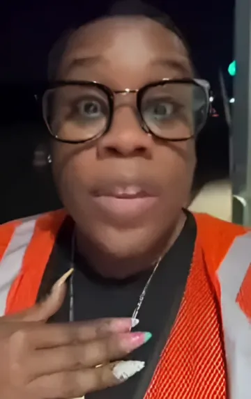 Frau in orangefarbener Weste und Brille zeigt Screenshot einer Fake-Facebook-Gruppe, die einen nationalen Restaurantboykott in den USA auslöste