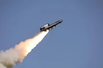 Ракета в полете с ярким огненным следом на фоне чистого голубого неба — иллюстрация к статье о вирусном фейке