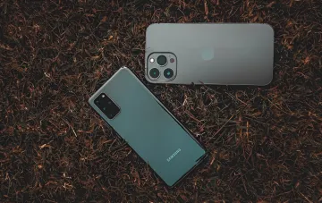 iPhone 17 und ein Samsung-Galaxy-Flaggschiff auf trockenem Gras — Spitzenreiter des Smartphone-Rankings im Q2 2026