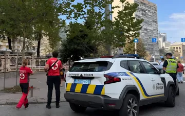 Патрульний автомобіль поліції та рятувальники на вулиці Києва після атаки дронів