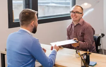 1:1 meeting between an employee and a manager: discussing career growth and promotion questions at the office desk