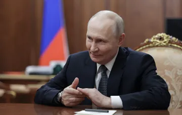 Владимир Путин на фоне российского флага в кабинете на фоне сообщений Bloomberg о подготовке Москвы к усилению баллистических ударов по Киеву после срыва переговоров