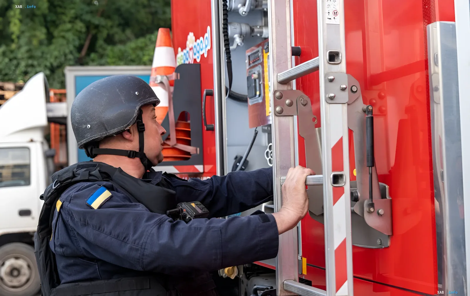 Рятувальник у шлемі та захисному жилеті працює на місці події після удару дрона по торговому центру в Харкові