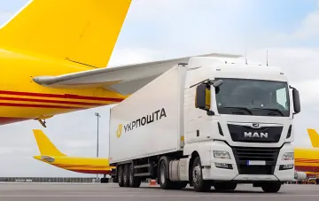 MAN-LKW mit Ukrposhta-Logo auf dem Flughafenvorfeld neben einem Flugzeug – Start des eigenen Luftfracht-Sicherheitsdienstes für internationale Pakete