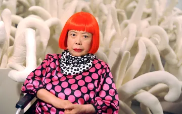 Yayoi Kusama, die japanische Künstlerin, bekannt für ihre 'unendlichen Punkte', in einem rosa gepunkteten Kleid vor einer weißen Skulptur-Installation