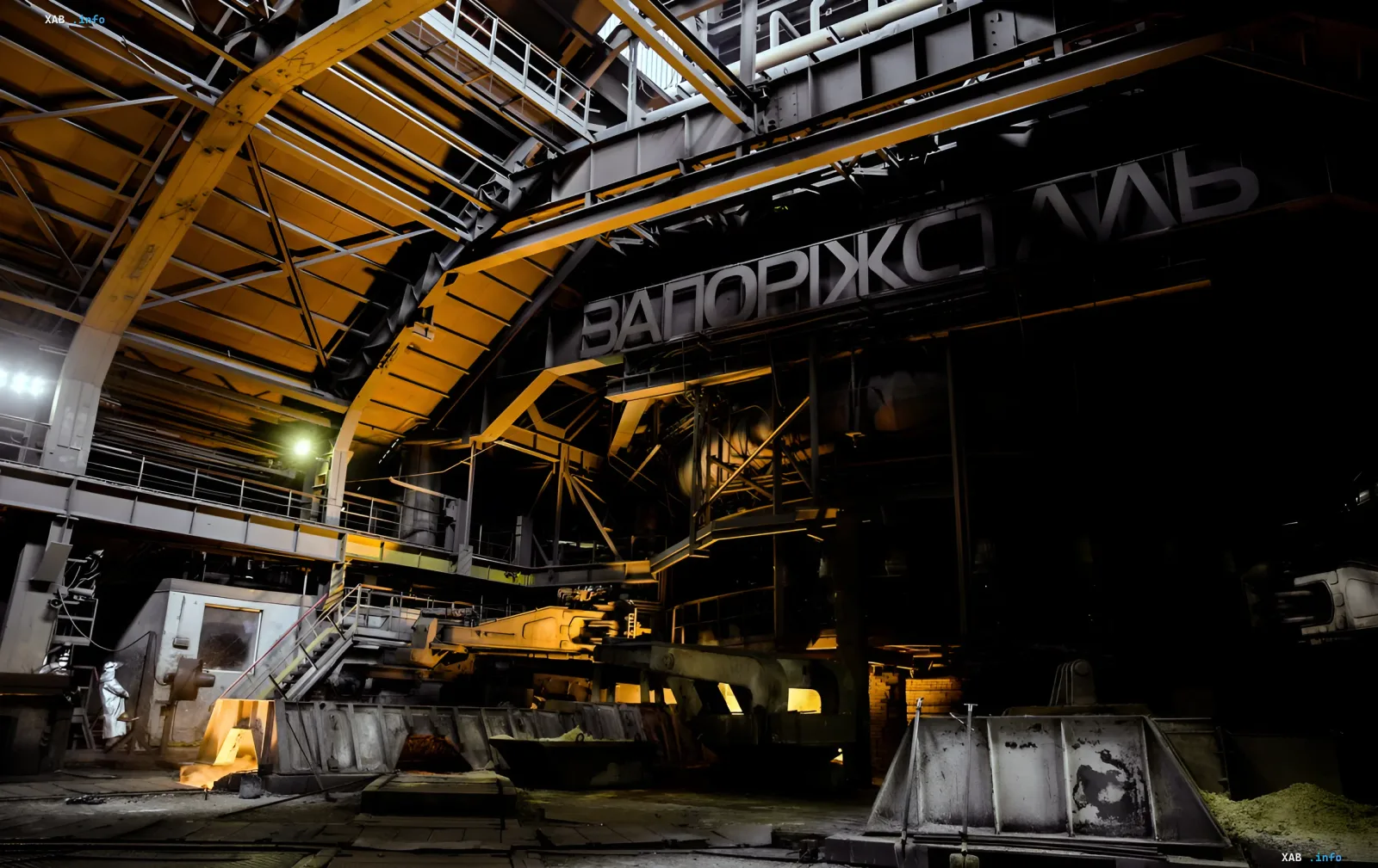 Walzwerk des Stahlwerks Saporischtschalsch mit dem Werksnamen am Gebäude nach dem nächtlichen Angriff: stillgelegte Produktion und dunkle Hallen des Komplexes