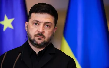 Volodymyr Zelenskyy in front of the Ukrainian and EU flags during a statement on air defense strengthening and ballistic missile protection via PURL