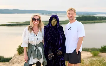 Autoren des Fantasy-Romans 'Hort' Badojew und Nawrozcka mit der Hort-Maske vor den Wassern des Dnipro bei der Präsentation des zweiten Teils