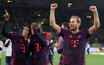 Bayern Munich players in dark away kits celebrate on the pitch — Bundesliga 2026/27 season preview