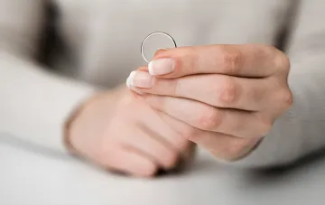 Frauenhand hält einen Ehering — Volksglaube, wenn der Ring fällt