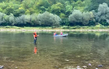 Rettungsschwimmer in Warnwesten arbeiten im flachen Dniester bei Sjaschischtschy vor dem Hintergrund eines historisch niedrigen Wasserstands